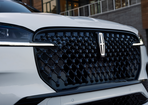The black grille of a white 2025 Lincoln Aviator® SUV is shown with its fog lights on. | Astro Lincoln in Pensacola FL