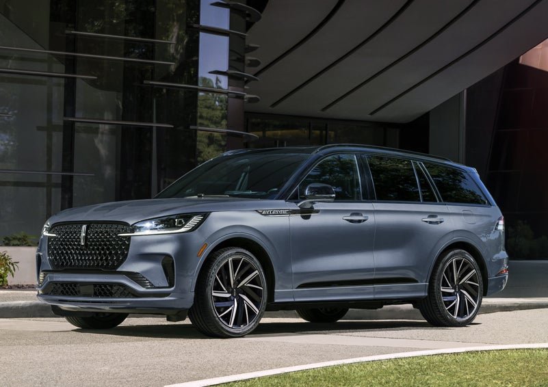A gray 2025 Lincoln Aviator® SUV is parked outside a modern building showcasing the driver’s side of the vehicle. | Astro Lincoln in Pensacola FL