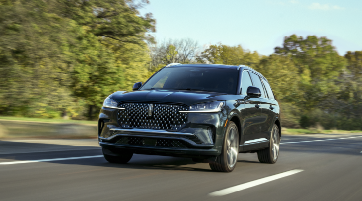 A 2025 Lincoln Black Label Aviator® SUV is being driven down a road lined with trees. | Astro Lincoln in Pensacola FL