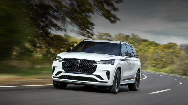 A white 2025 Lincoln Aviator® SUV is being driven down a road lined with trees. | Astro Lincoln in Pensacola FL