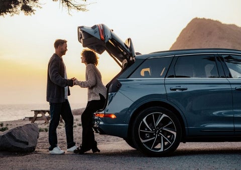 A couple share a moment together outside a 2025 Lincoln Corsair® SUV near the open liftgate. | Astro Lincoln in Pensacola FL