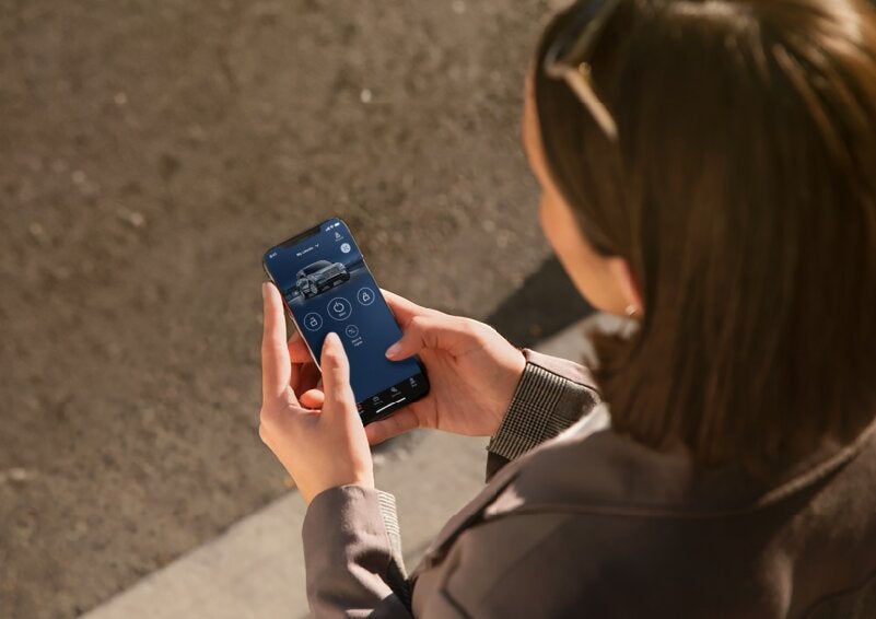 A person is shown interacting with a smartphone to connect to a Lincoln vehicle via the Lincoln Way® App. | Astro Lincoln in Pensacola FL