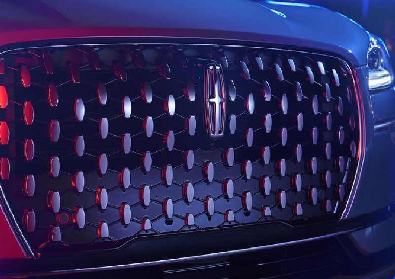 The grille of a 2025 Lincoln Corsair® SUV reflects neon light at night. | Astro Lincoln in Pensacola FL