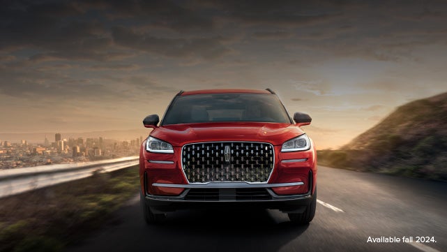 A 2025 red Lincoln Corsair® SUV is being driven down a road at sunset. | Astro Lincoln in Pensacola FL