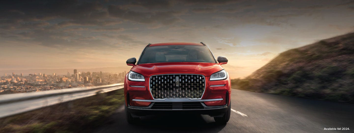 A 2025 red Lincoln Corsair® SUV is being driven down a road at sunset. | Astro Lincoln in Pensacola FL