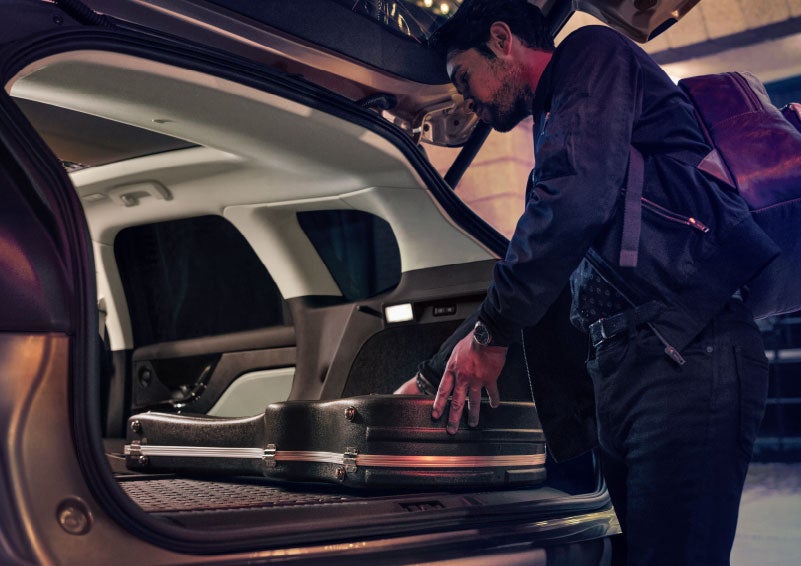 A man is shown loading cargo into the rear of a 2024 Lincoln Corsair® SUV with the second-row seats folded flat. | Astro Lincoln in Pensacola FL