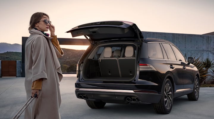 A woman approaches a 2026 Lincoln Aviator® SUV with its rear liftgate open. | Astro Lincoln in Pensacola FL