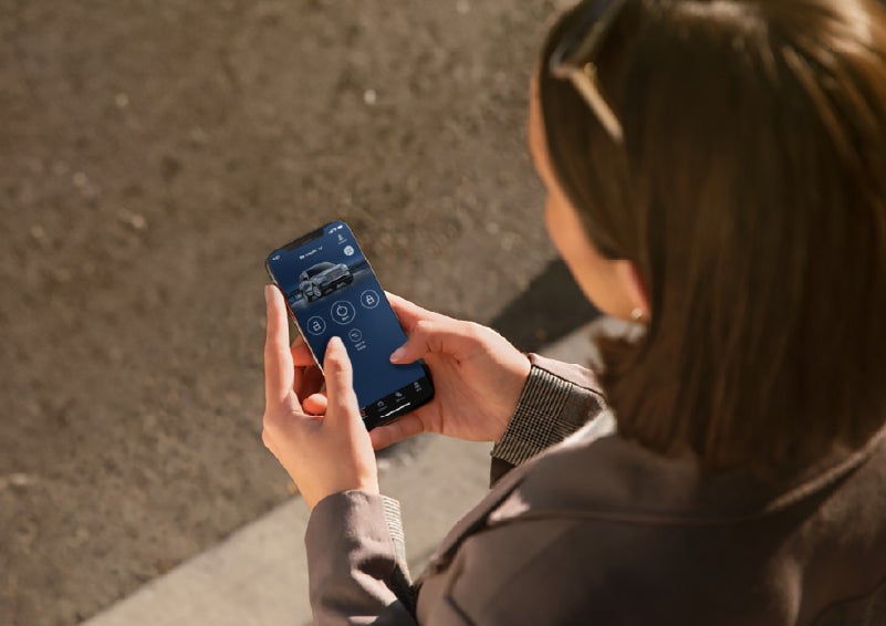 A person is shown interacting with a smartphone to connect to a Lincoln vehicle via the Lincoln Way® app. | Astro Lincoln in Pensacola FL