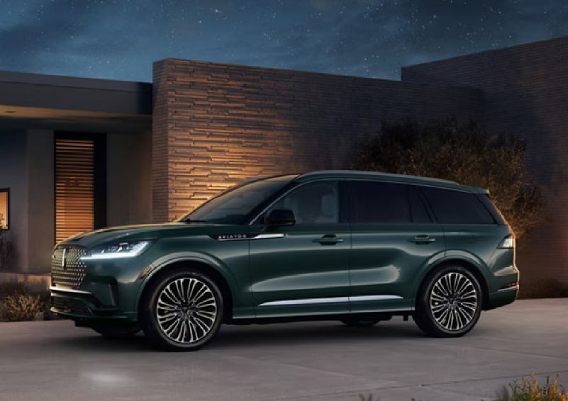 A green 2027 Lincoln Aviator® SUV is parked outside a contemporary home. | Astro Lincoln in Pensacola FL