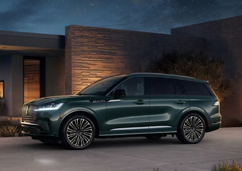 A green 2027 Lincoln Aviator® SUV is parked outside a contemporary home. | Astro Lincoln in Pensacola FL