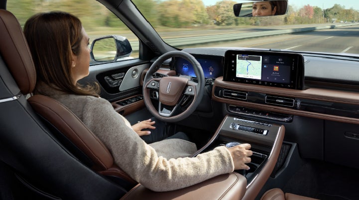 A 2027 Lincoln Aviator® SUV is being driven hands-free on a highway lined with trees. | Astro Lincoln in Pensacola FL
