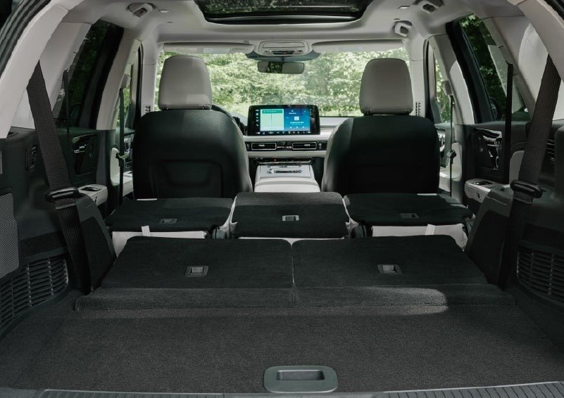 A rear to front view of the interior of a 2027 Lincoln Aviator® Black Label™ SUV shows the third and second rows folded flat | Astro Lincoln in Pensacola FL